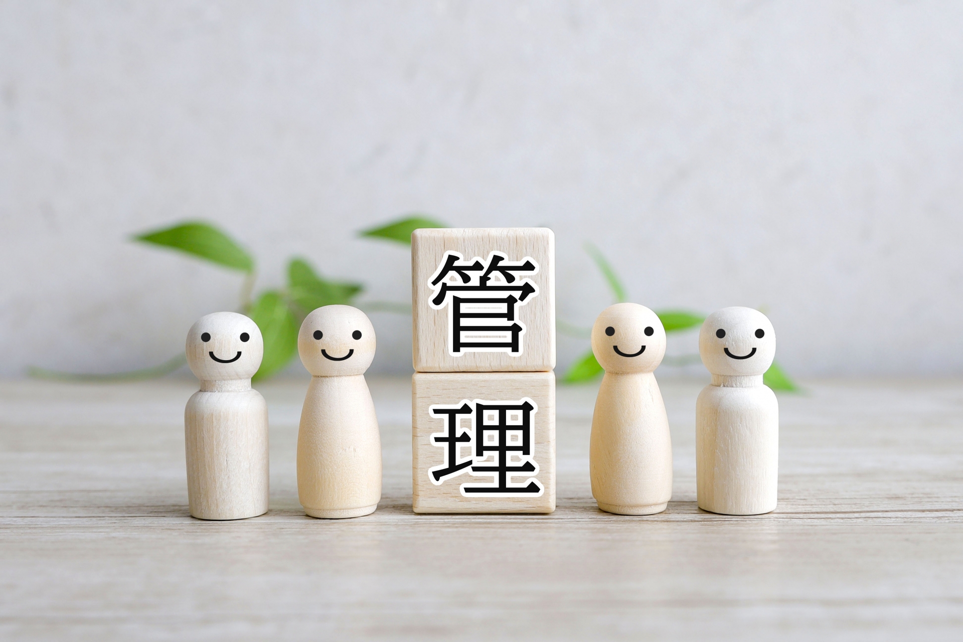管理　と書かれている縦に積んだ積み木2つと4つの白い木の人形