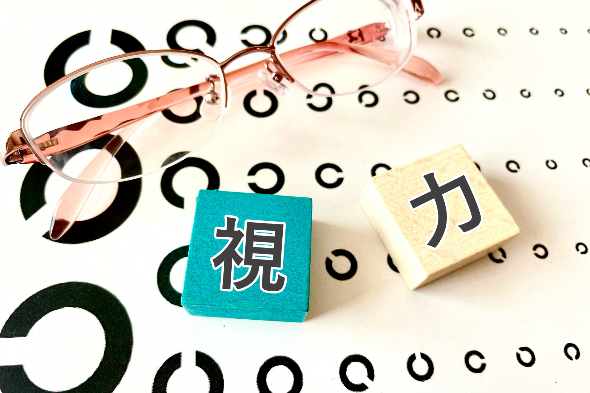 視力　と書かれた積み木2つと視力検査の輪っか